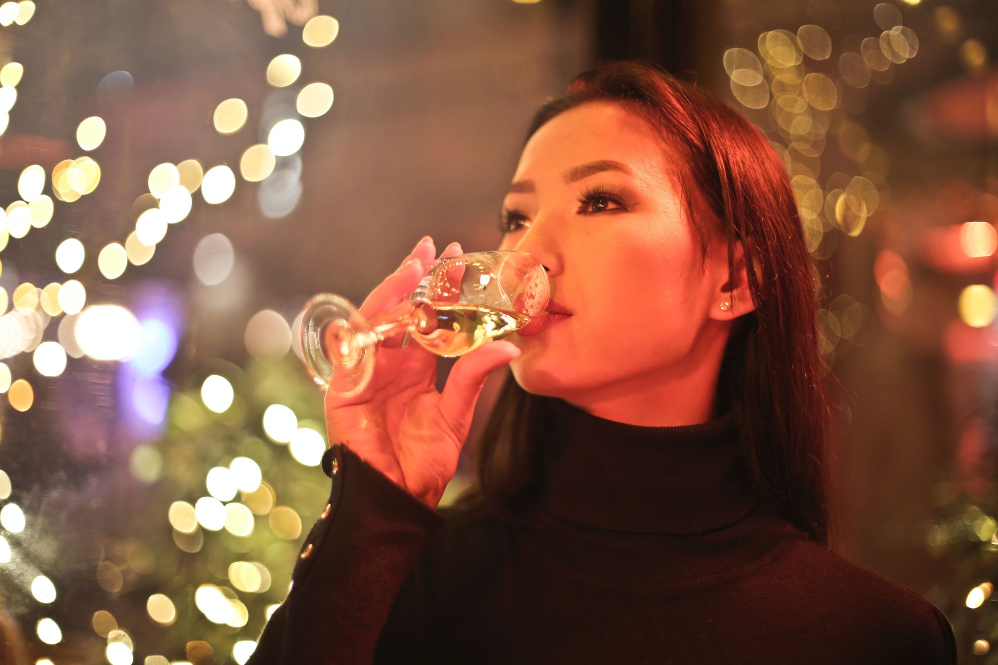 A person drinking wine from a wine glass